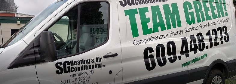 One of SG Heating & Air Conditioning LLC's company vehicles sits near the company's office. The company's name, as well as the words "TEAM GREEN" the company's trademarked slogan, are prominently displayed. 